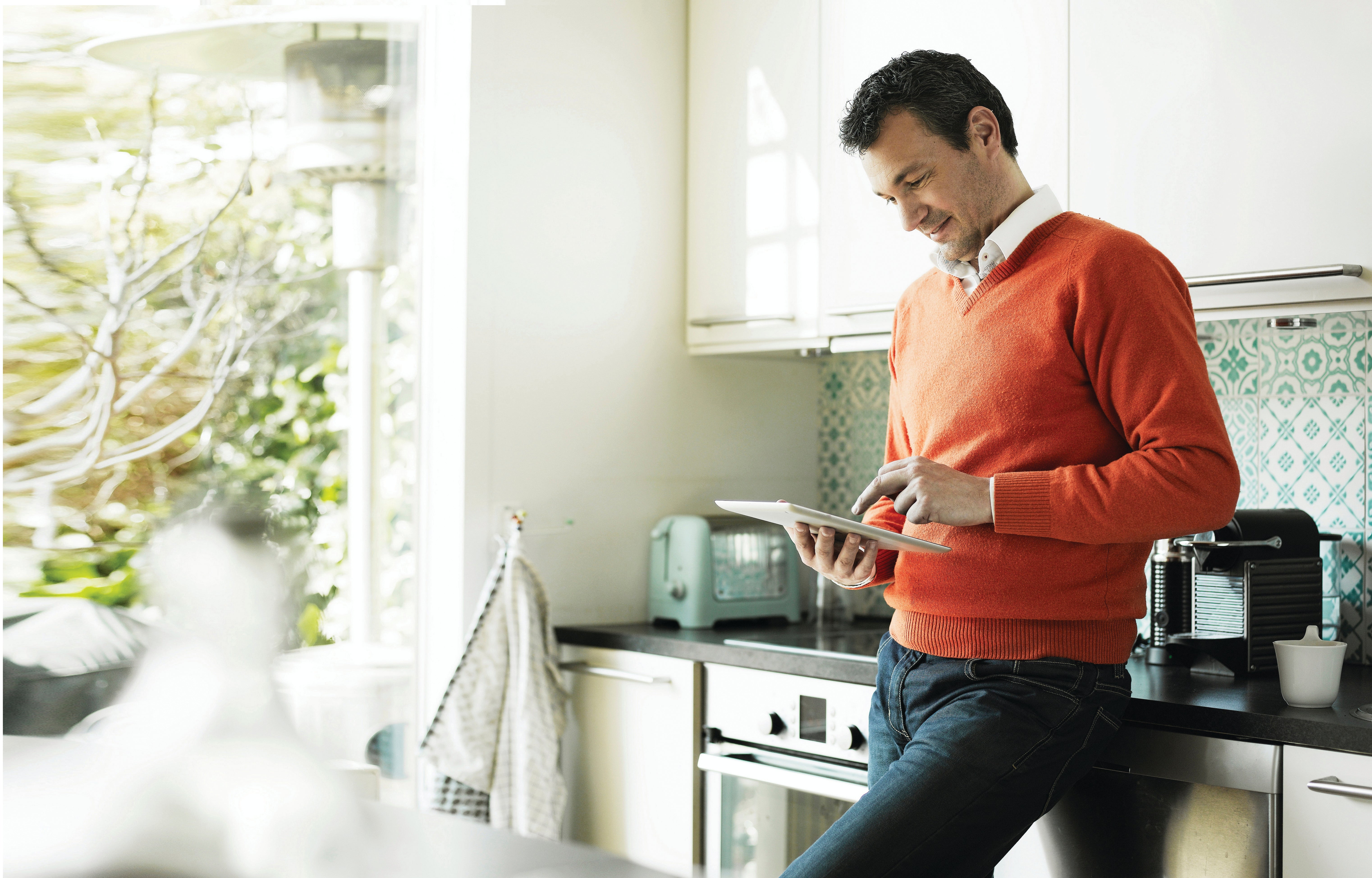 Mature man using tablet in kitchen