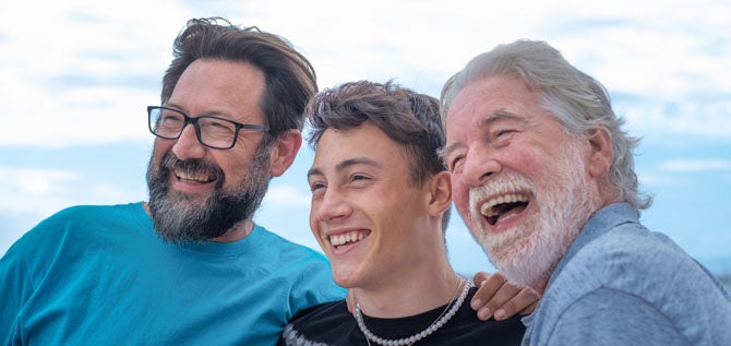 three generations of men smiling outdoors