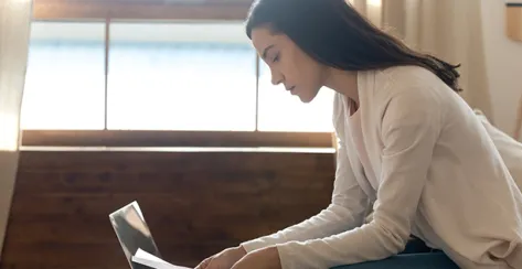 Thoughtful young caucasian woman sit on sofa at home reading paperwork letter or bank notice, pensive female receive unpleasant news in paper post correspondence, have debt or financial problem